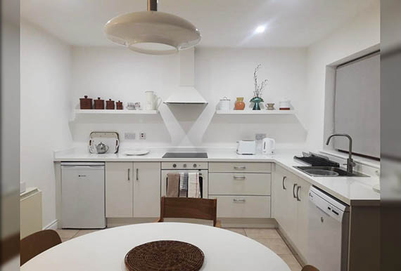 Small ivory fitted Kitchen with white worktops Image